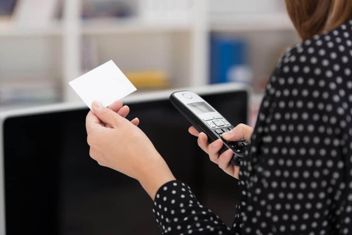 Woman dialing out on her mobile phone Telefonservice bei Abwesenheit richtig nutzen.